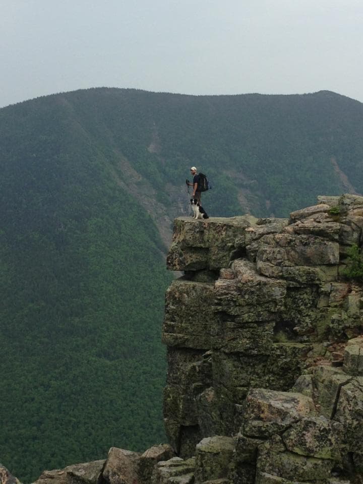 Nick and his dog Gus standing on the edge of Bondcliff